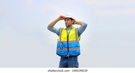 Contractor Engineers Or Construction Specialists Wearing A Reflective Vest Standing Outdoors. Caucasian Architect Is Wearing Hard Hats Before Leaving For Work.