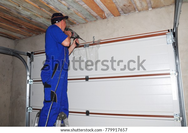 Contractor Installing Garage Door Drilling Hole Stock Photo