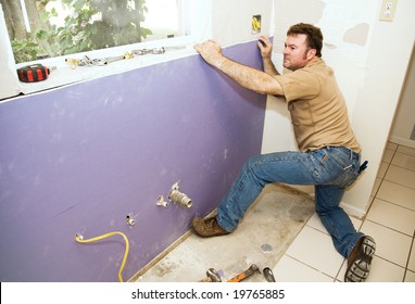 Contractor Installing A Large Piece Of Drywall During A Kitchen Remodel.