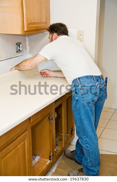 Contractor Installing New Laminate Kitchen Counter People