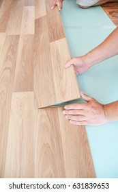 Contractor Installing Wooden Laminate Flooring With Insulation And Soundproofing Sheets. Man Laying Laminate Flooring. Man Laying Laminate Flooring. 