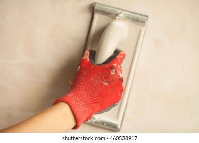 Contractor Sanding The Drywall Mud Using Sand Trowel