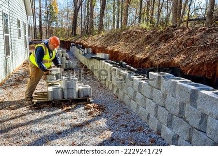 Contractor was seen installing concrete block wall that is being built on part new retaining wall construction project