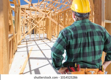 Contractor Standing Inside Construction Framing Of New House.