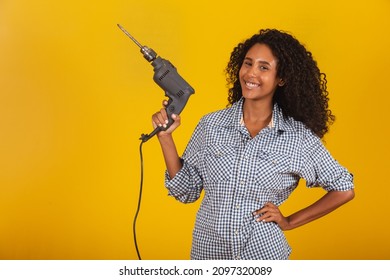 Contractor woman with a drill on yellow background.  - Shutterstock ID 2097320089