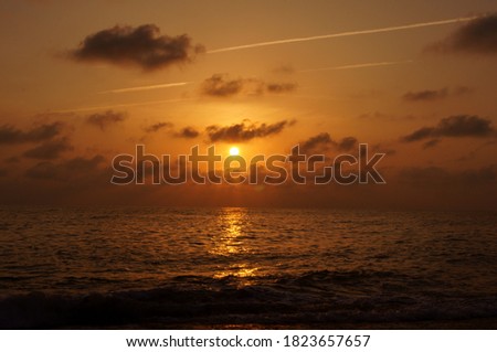 Contrails and clouds at sunset.