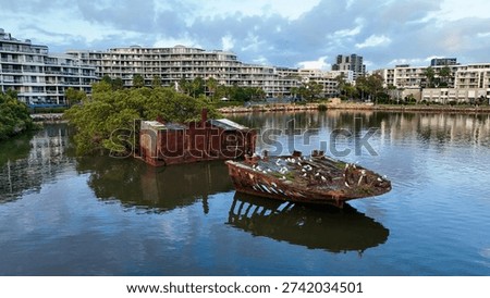 Contrast between SS Ayrfield's rusted wreck in Homebush Bay and modern luxury apartments at Wentworth Point, Parramatta, Sydney.