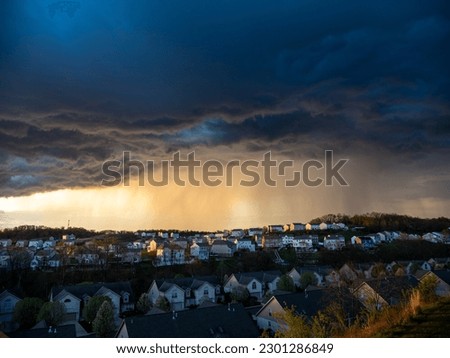 The contrast of sun-rays and dark clouds creates a dramatic scene over a US neighborhood before a bad weather hits.