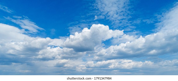Contrasting expressive clouds against the blue sky as a backdrop.
