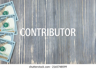 CONTRIBUTOR - word (text) on wooden background, money, dollars. Business concept (copy space).