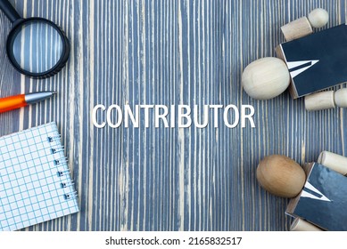 CONTRIBUTOR - word (text) on a wooden background, notepad and pen with calculator. Business concept (copy space).
