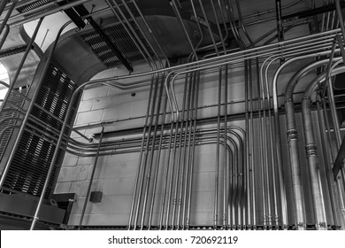 Control conduit and cable bus in an industrial facility.  Monochrome image.