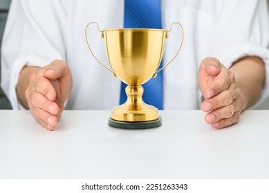 Control and dominate a market to protect products and services for market shares and success, business monopoly concept : Investor or seller or winner uses hands to protect a company gold trophy cup. - Shutterstock ID 2251263343