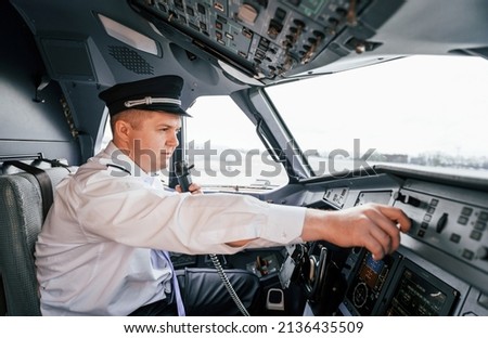 Control of the flight. Pilot on the work in the passenger airplane. Preparing for takeoff.