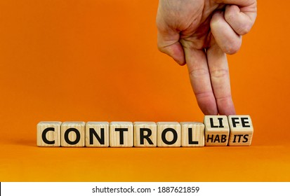 Control habits symbol. Businessman hand turns wooden cubes and changes words 'control habits' to 'control life'. Beautiful orange background, copy space. Business and control habits concept.