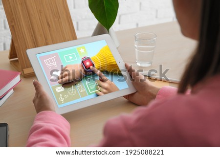Control kid's geolocation via smart watch. Woman using tablet at table, closeup