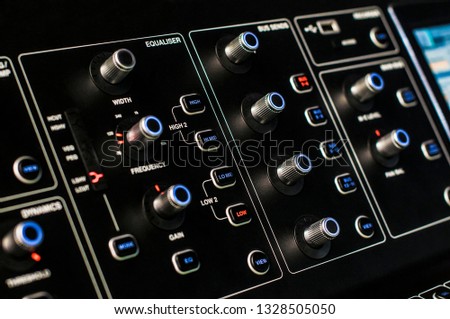 Control panel with backlight buttons and knobs. Studio DJ mixer equipment for party and convert making. Modern digital equaliser, soundboard console. Sound recording and broadcasting technology