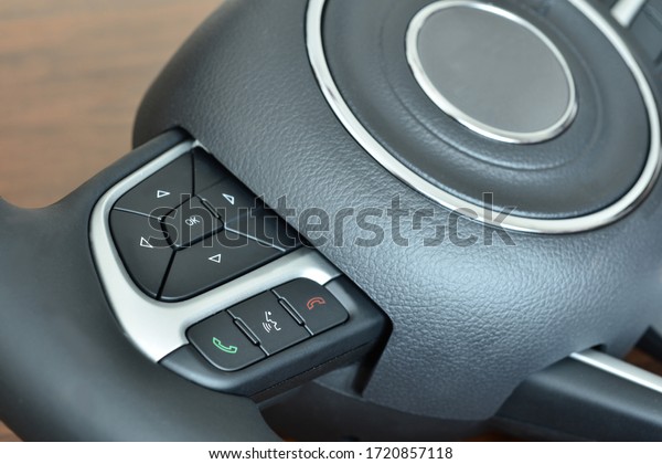Control panel of a\
car steering wheel. Panel has numerous button which serve several\
functions. Controls help driver to control operations without\
having to move this hands.\
