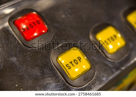 The control panel of a gaming machine features a row of illuminated square buttons in red and yellow. These 
