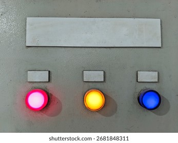 ​Industrial control panel with three indicator lights (red, yellow, blue). Shows status, warnings, or operation. Ideal for industrial, technology, and electrical themes.