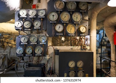 Control Panel With Vintage Manometers, Pressure Gauges And Thermometers In Boiler Room Of Steam Powered War Ship Or Batte Ship From World War Two Served In Royal British Navy In North Atlantic Ocean.