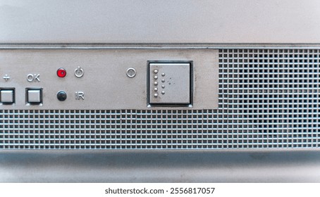 Control panel of a vintage vcr featuring volume buttons, power button, ir sensor, and a metallic grid, evoking nostalgia for retro technology - Powered by Shutterstock