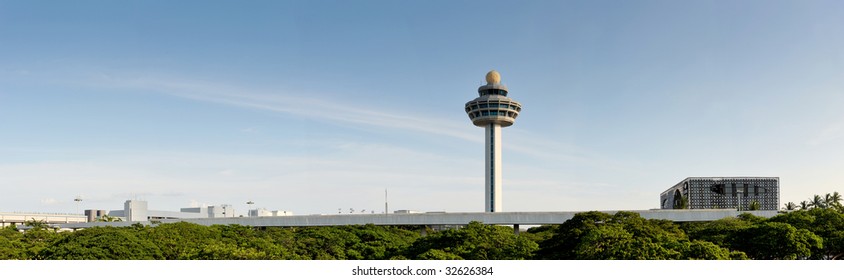 The Control Tower Of Changi Airport In Singapore. This Panoramic Shows Off The Garden City's Green Trees, Blue Skies And Cleanliness. The Air Traffic Control Tower Sticks Out Into The Sky.