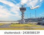 Control tower at a passenger airport against the background of an airplane taking off into the sky