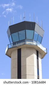 A Control Tower At A Small Regional Airport Against Blue Sky And Clouds