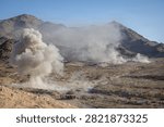 A controlled explosion erupts down range while U.S. Marines with Golf Company, 2nd Battalion, 2nd Marine Regiment, 2nd Marine Division, take cover behind a berm during a live-fire company attack on Range 400 during Service Level Training Exercise 4-26 on Marine Corps Air Ground Combat Center, Twentynine Palms, California, July 29, 2026. 