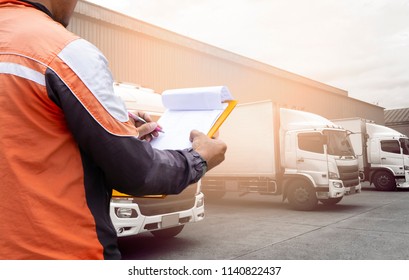 Controller man holding a clipboard inspecting loaded cargo with a truck