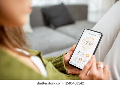 Controlling heating temperature with a smart phone, close-up. Concept of a smart home and mobile application for managing smart devices at home - Powered by Shutterstock