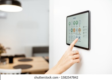 Controlling Home With A Digital Touch Screen Panel Installed On The Wall. Close-up On A Screen With Mobile Application For Managing Smart Devices