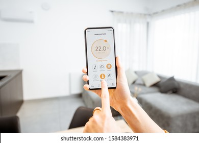 Controlling home heating temperature with a smart home, close-up on phone. Concept of a smart home and mobile application for managing smart devices at home - Shutterstock ID 1584383971
