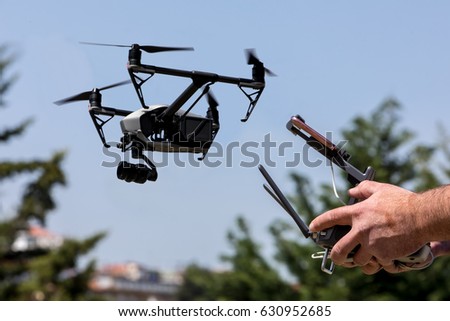 Controlling a remote helicopter drone. Drone flight remote controller in man hands