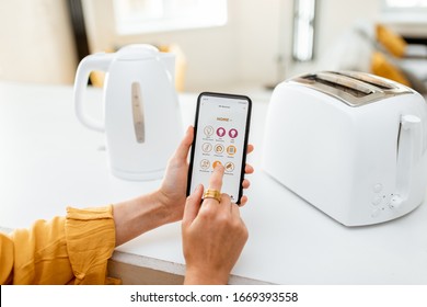 Controlling Smart Kitchen Appliance Using Mobile Phone At Home, Close-up On Mobile Screen. Concept Of A Smart Home Devices