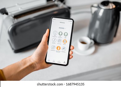 Controlling Smart Kitchen Appliance Using Mobile Phone At Home, Close-up On Mobile Screen. Concept Of A Smart Home Devices