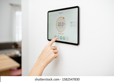 Controlling Temperature In The Living Room With A Digital Touch Screen Panel Installed On The Wall. Concept Of Heating Control In A Smart Home, Close-up On A Screen