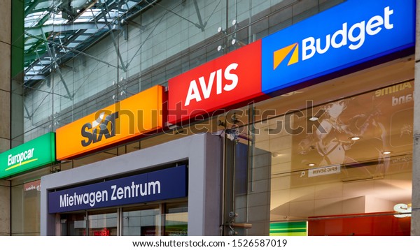 Convenient car rental central booking office located
inside the main train station in Cologne, Germany.  August 2019.
Signs include Sixt, Europcar, Avis and Budget.                     
        