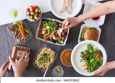 Convenient Takeaway Takeout Food For Party, Overhead Spread Of Assorted Food With Hands Serving Up