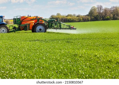Conventional intensive agriculture - spreading pesticide on a cereal field in spring - Shutterstock ID 2150810367