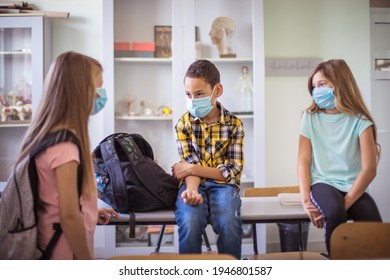 Conversation Before Class. Small Group Of School Children In Classroom Talking. With Face Mask. 