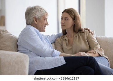 Conversation of older man and adult daughter. Serious attentive young woman sit on sofa and listen old dad talking about health problems, life concerns, share news feeling support form loving daughter - Powered by Shutterstock