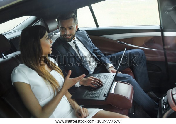 Conversation of two\
business people in driving\
car