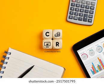 Conversion rate optimization concept. The acronym CR conversion rate on wooden cubes over yellow office desktop background.