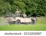 converted open-top british army land rover defender 110 wolf 4x4 in action on a military exercise, Wilts UK