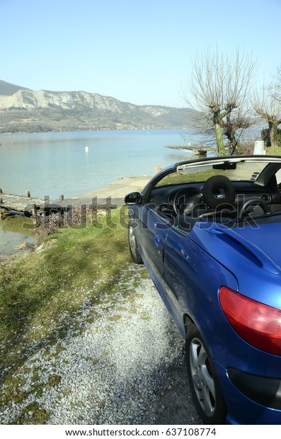 Convertible car and Annecy lake : blue convertible\
car along Annecy lake in\
France