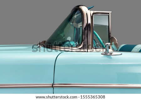 Convertible windshield and drivers seat. side view of a aqua blue classic car's windscreen and steering wheel. isolated on gray. 