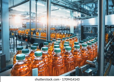 Conveyor belt, juice in bottles, beverage factory interior in blue color, industrial production line. - Shutterstock ID 1709414143