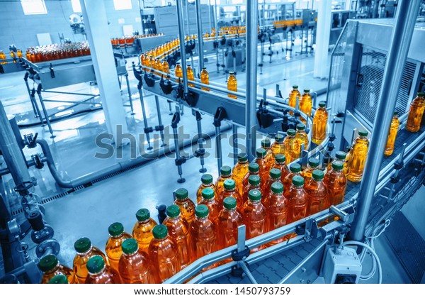 Conveyor\
belt, juice in bottles on beverage plant or factory interior in\
blue color, industrial production line,\
toned